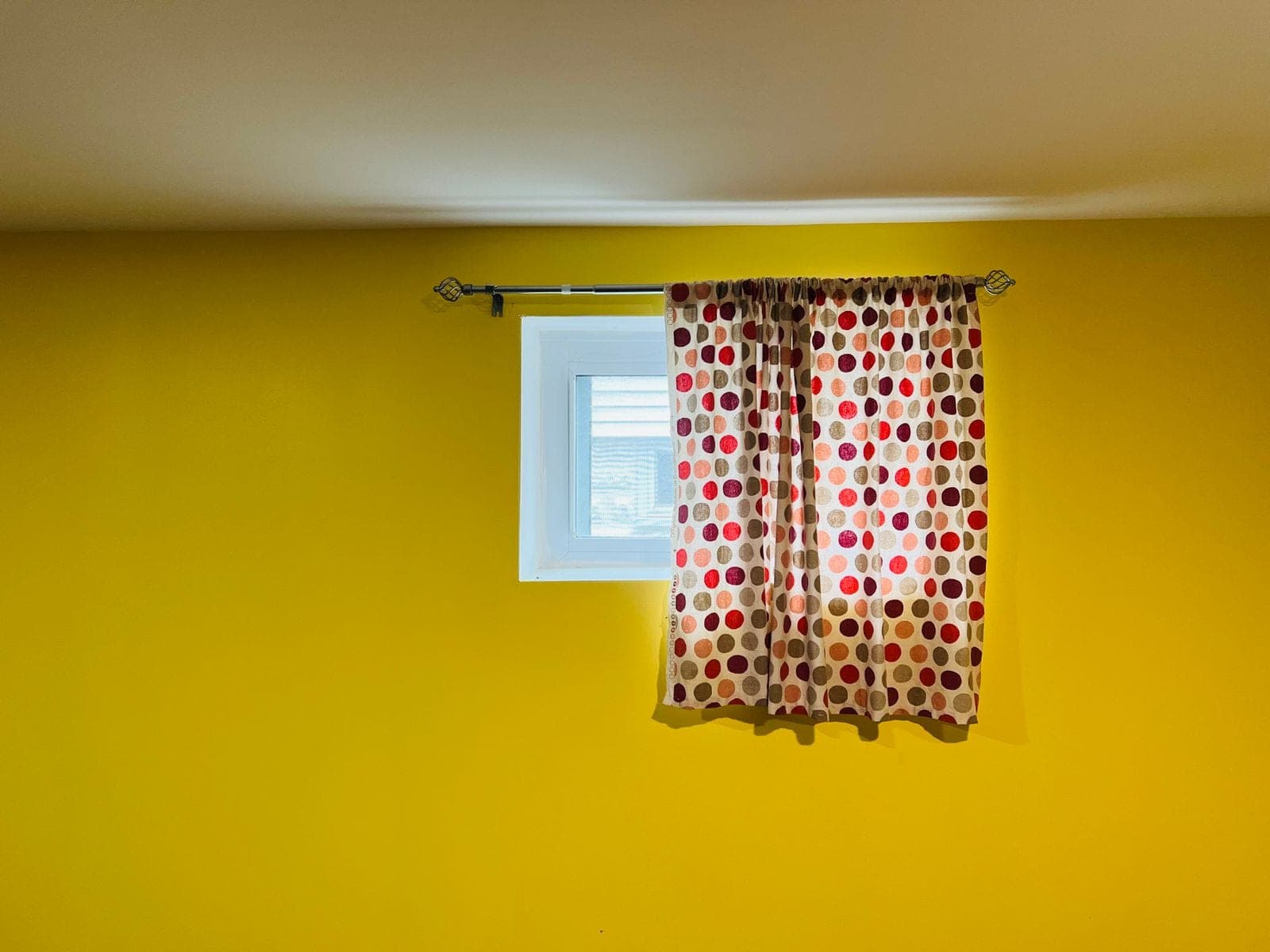 Small basement window high on a painted wall