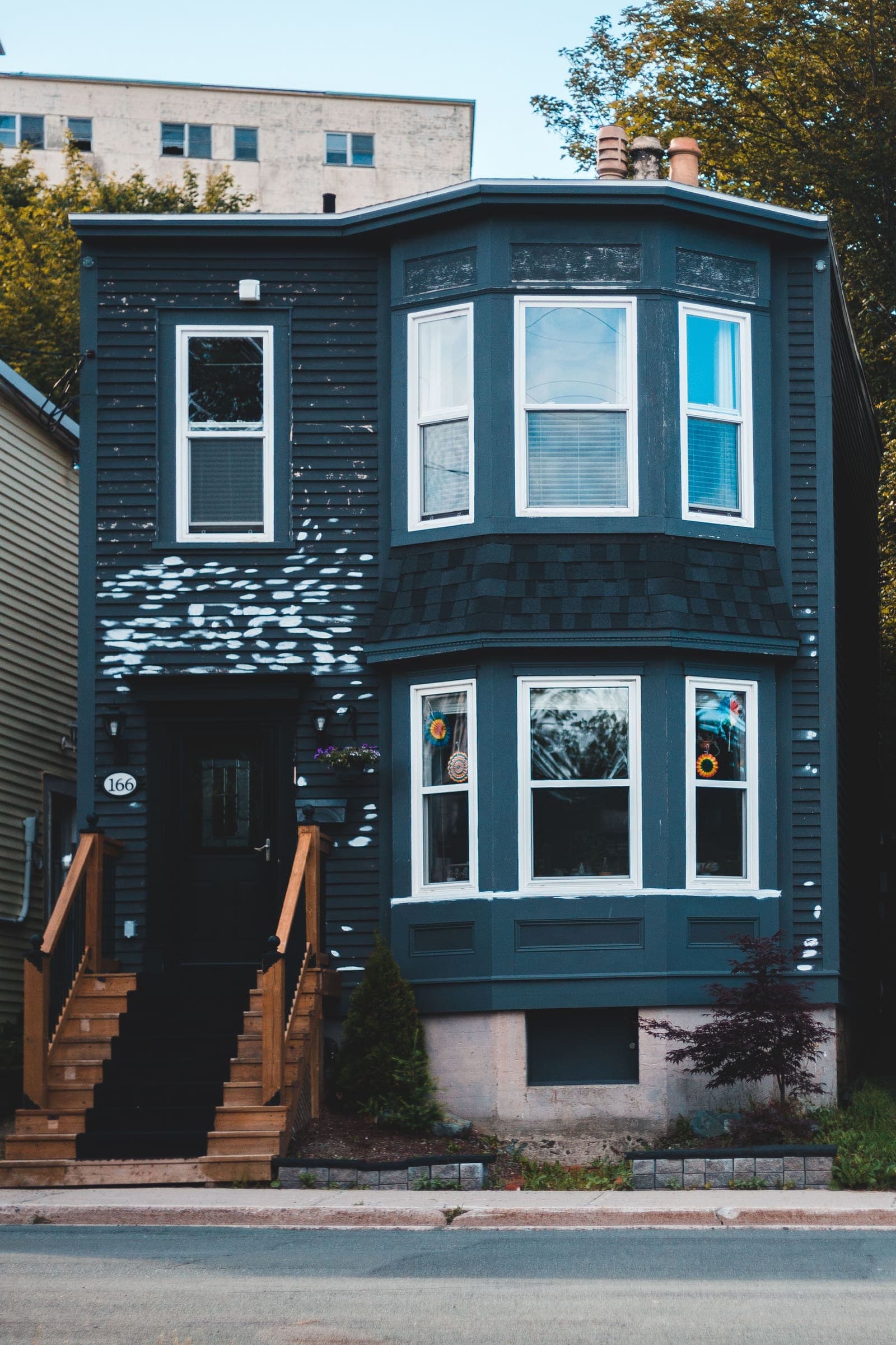 Two-storey house with a stacked bay of white windows