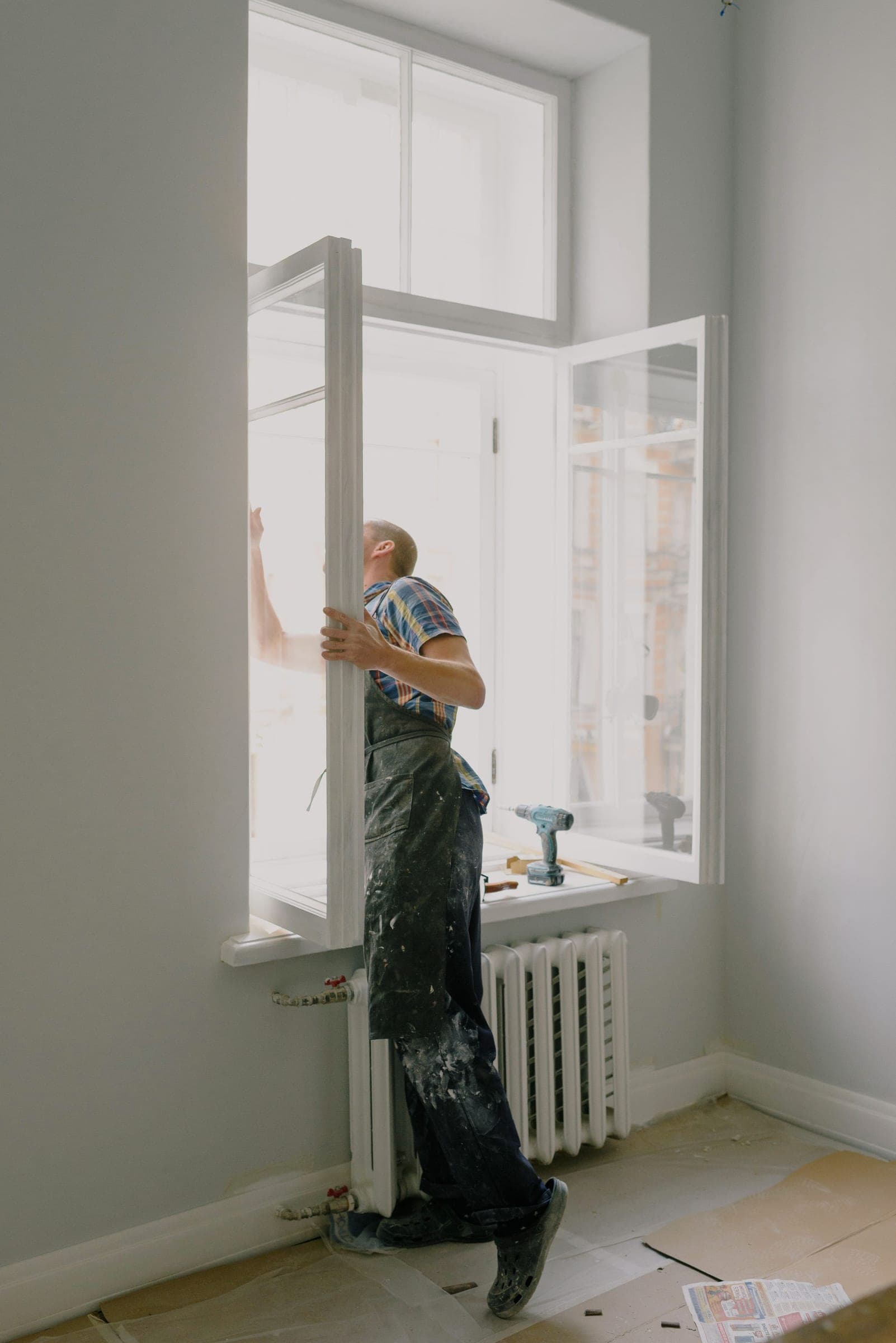 Installer standing on the sill fitting an opening casement sash