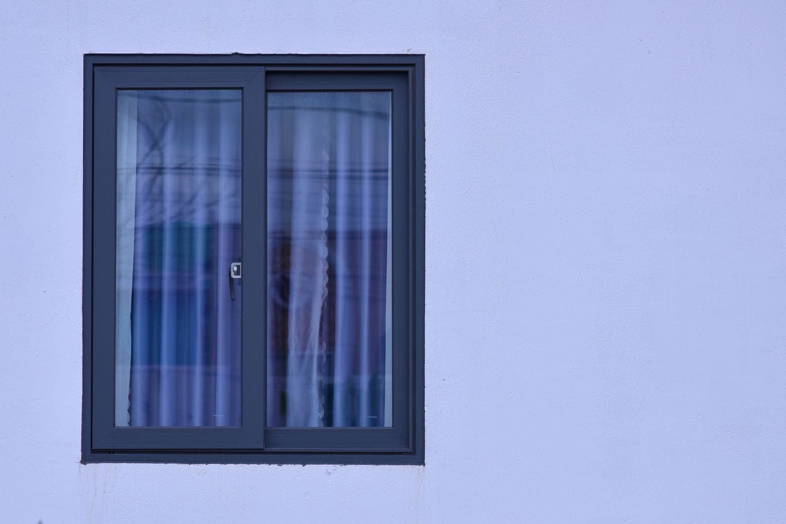 Dark-framed sliding window on a white wall